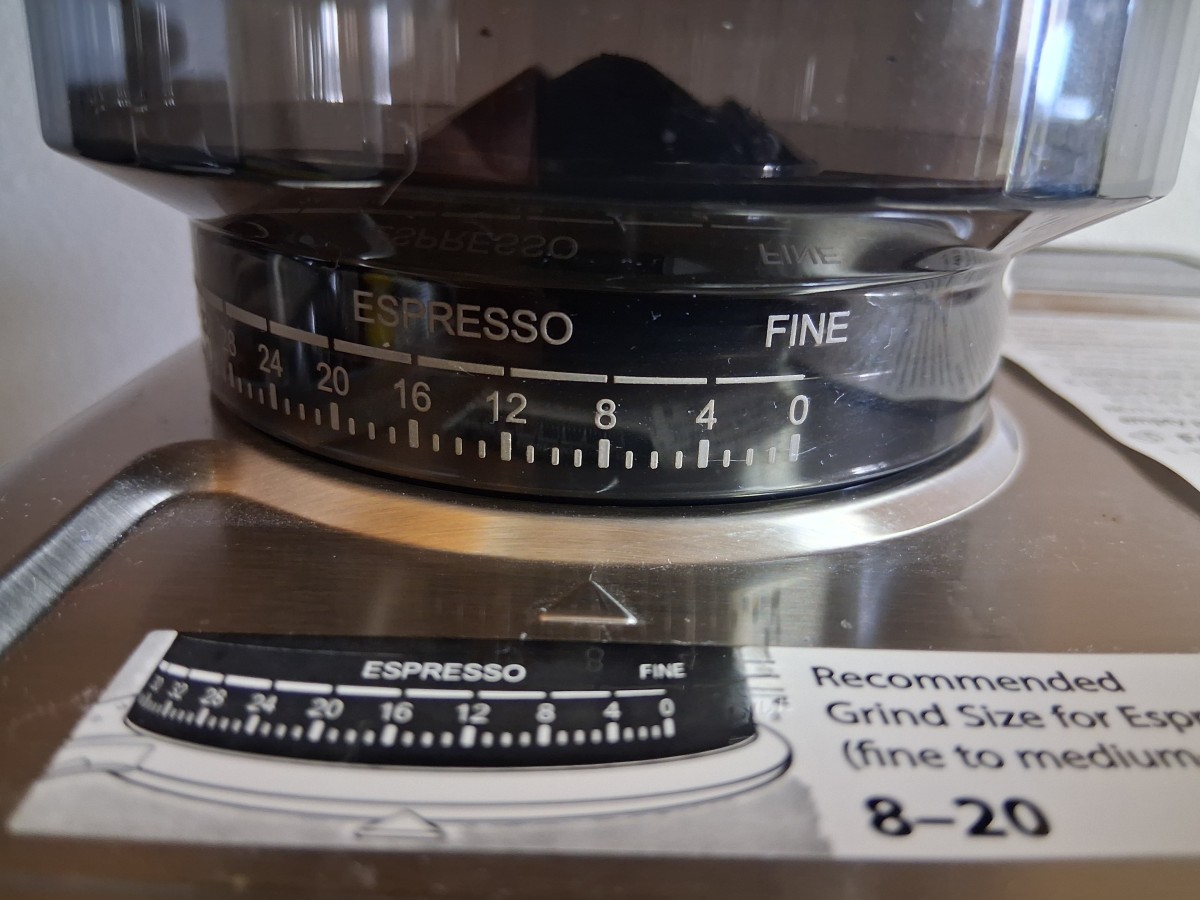 Close-up of the AMZCHEF CM1626 grinder dial set to 8, showing the manufacturer's recommended espresso grind range of 8–20