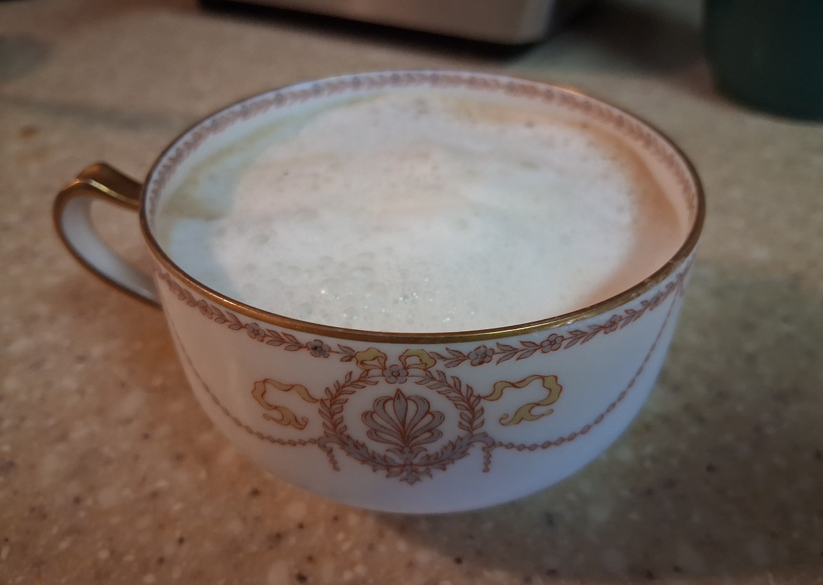 Decorative white and gold ceramic cup filled with freshly prepared milk foam from the AMZCHEF CM1626