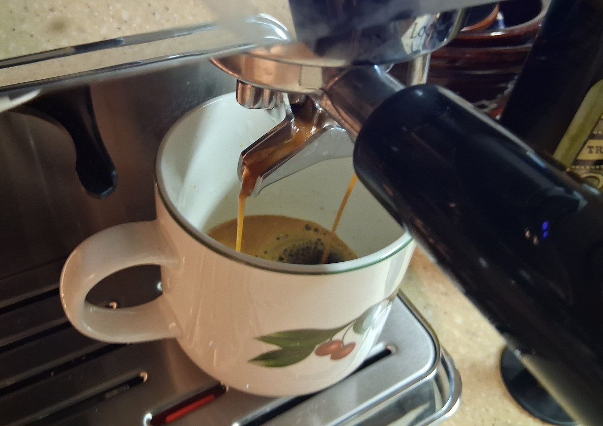 Fresh espresso flowing from the AMZCHEF CM1626 portafilter into a ceramic coffee cup during hands-on testing