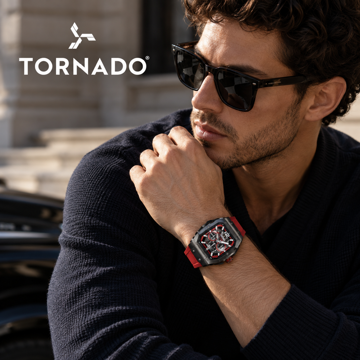 Man wearing a red-strap Tornado watch with a dark tonneau case and skeleton-style dial