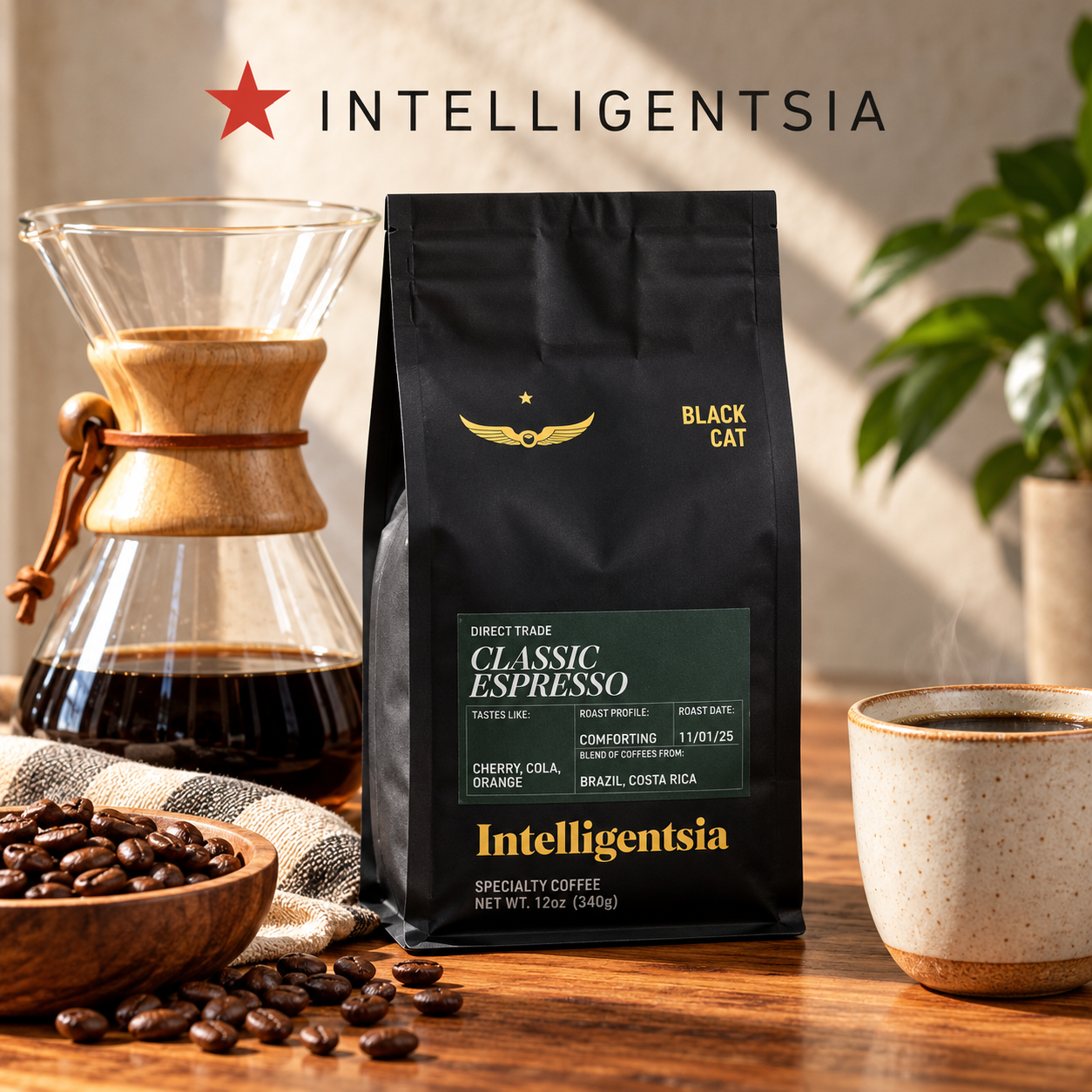 Intelligentsia Black Cat Classic Espresso coffee on a table beside a glass coffee brewer and ceramic mug